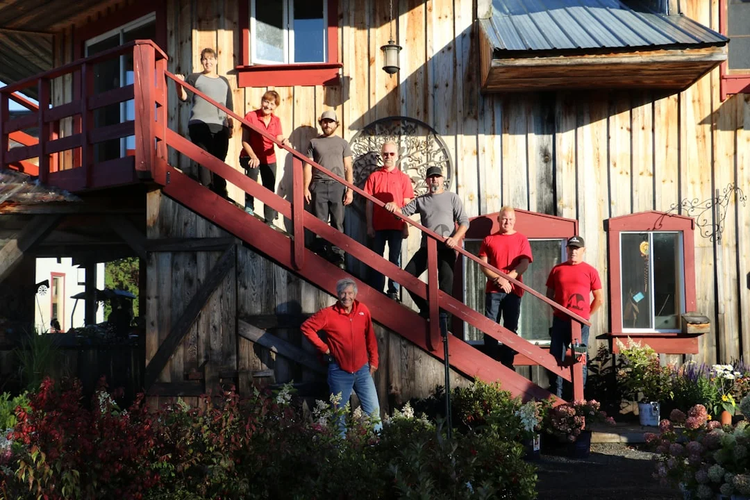A group of people standing outside of a wooden house