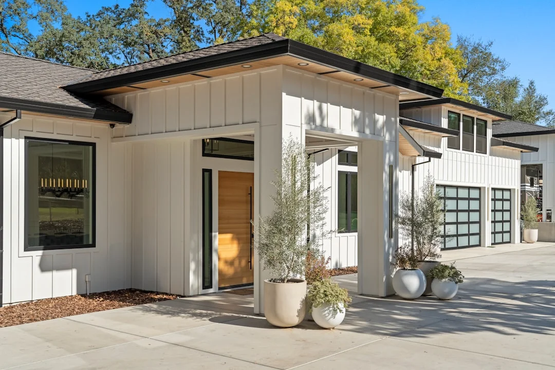 Modern White House with Garage Modern white house with glass garage doors and plants