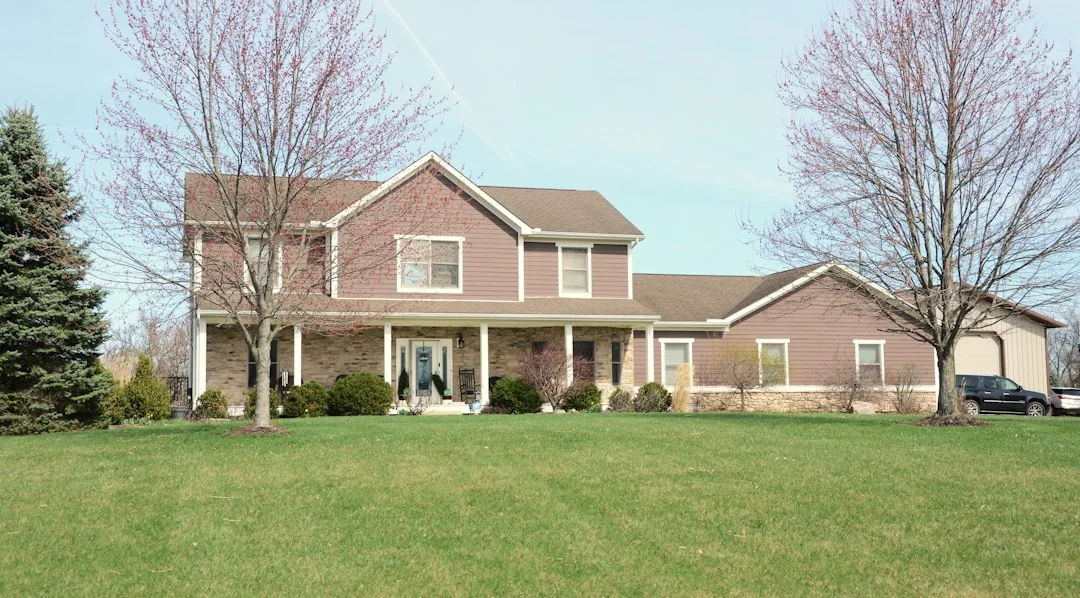 Suburban House with Gabled Roof A large suburban house with a green lawn.