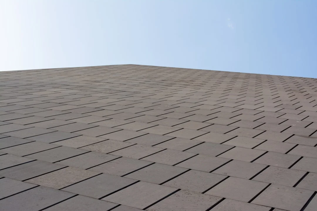 Brown textured wall against a clear blue sky