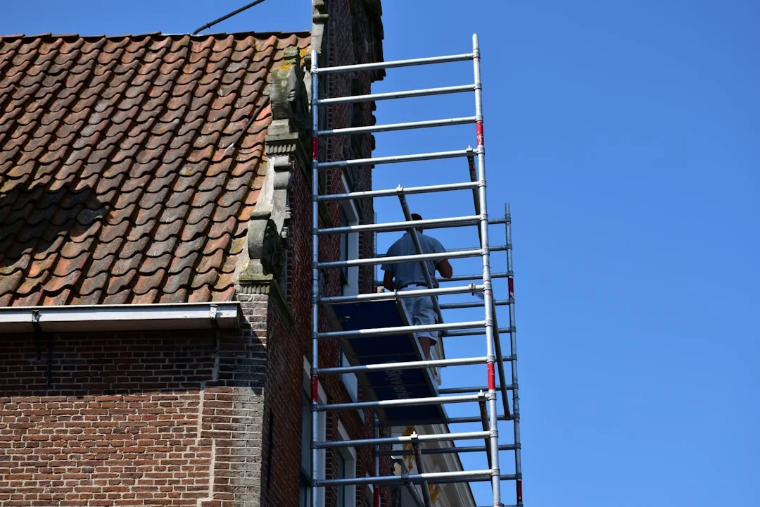Roof Work on Brick Building Worker on scaffolding next to brick building