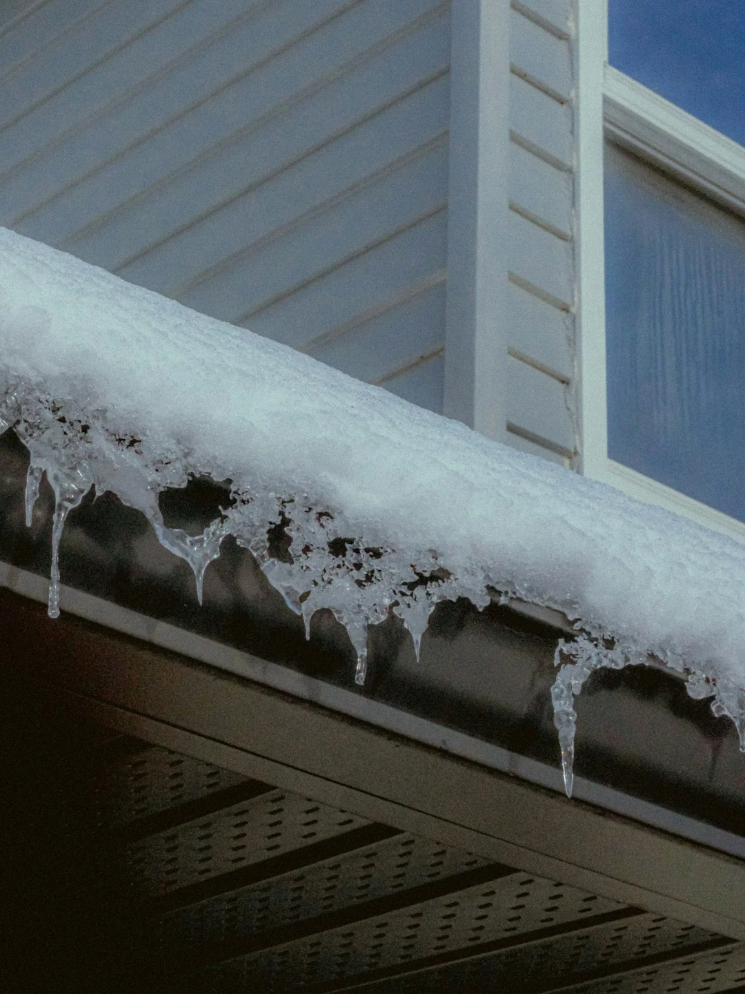 Snow-Covered Roof with Icicles Icicles hang from a snow-covered roof gutter.