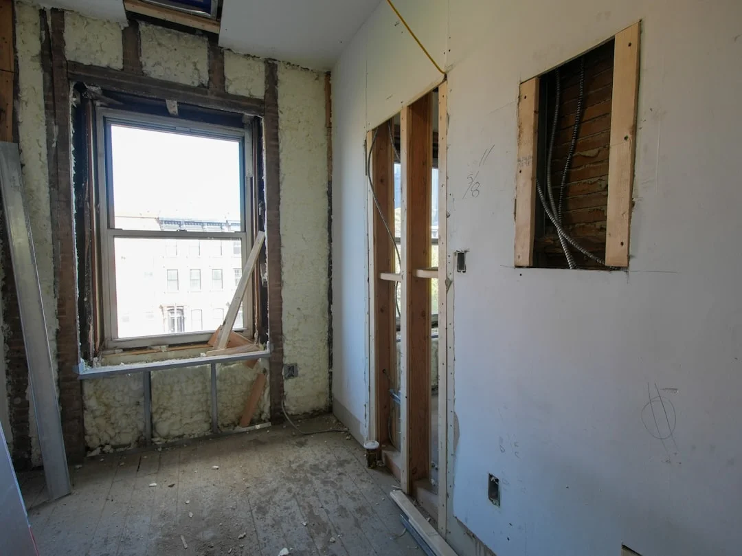 Room Renovation Project Interior room undergoing renovation with exposed walls and window.