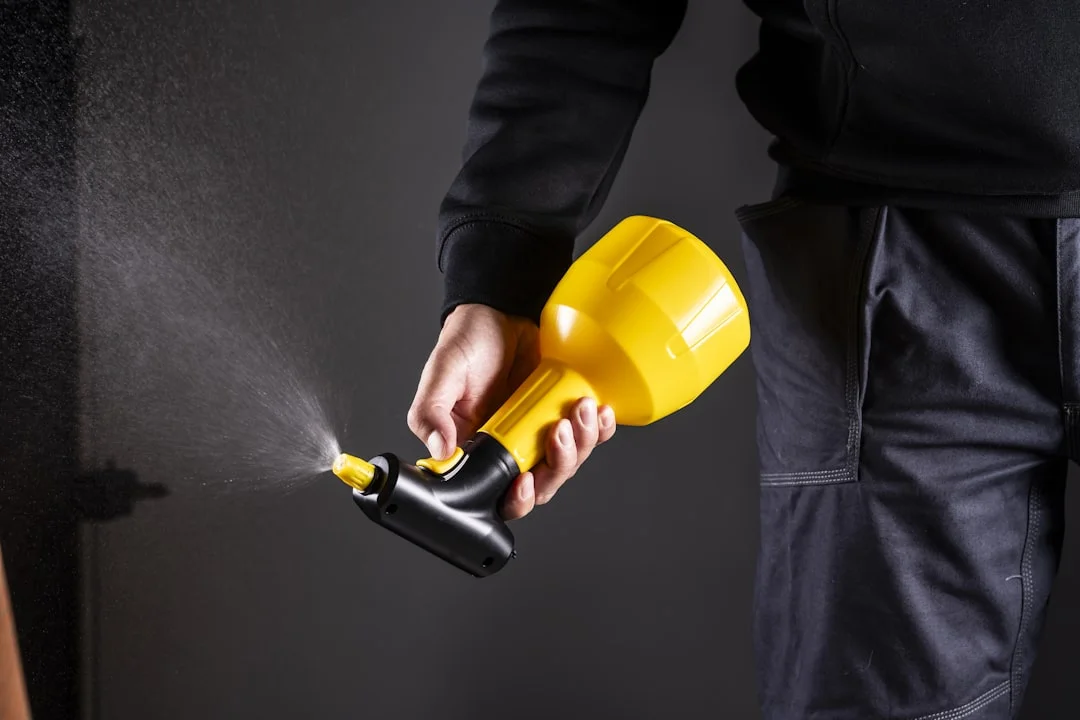 Roof Coating Application A person is holding a spray gun.