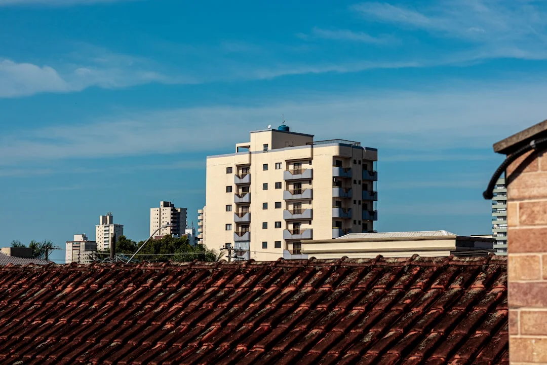 Cityscape with Terracotta Roof Modern buildings rise above a terracotta roof against blue sky.