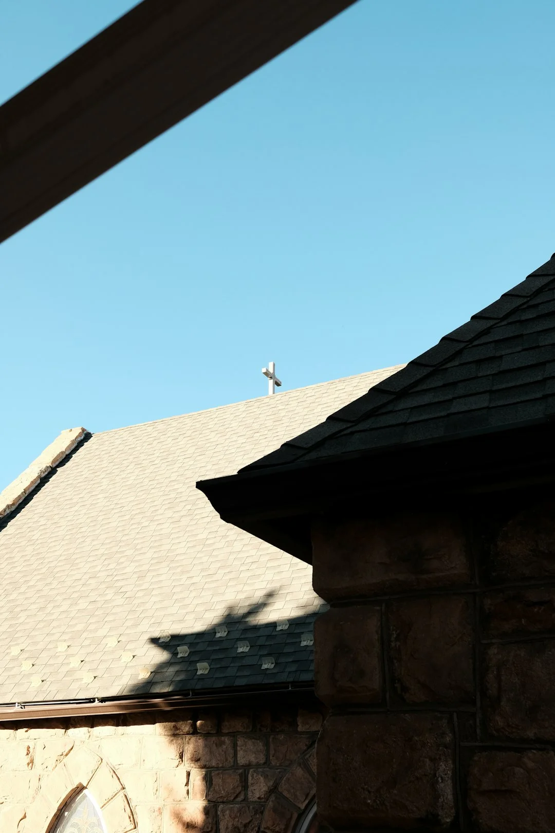 Stone Building with Sloped Roof a small airplane flying over a roof of a house